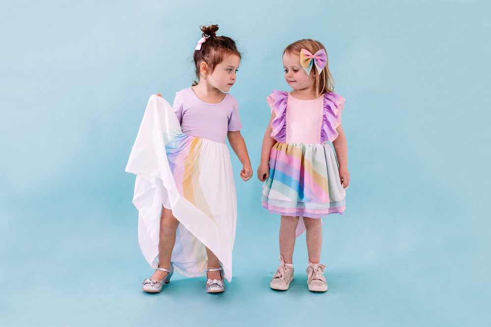 two friends holding hands. One is wearing the pastel rainbow ballerina and the other is wearing the pastel chiffon shortie