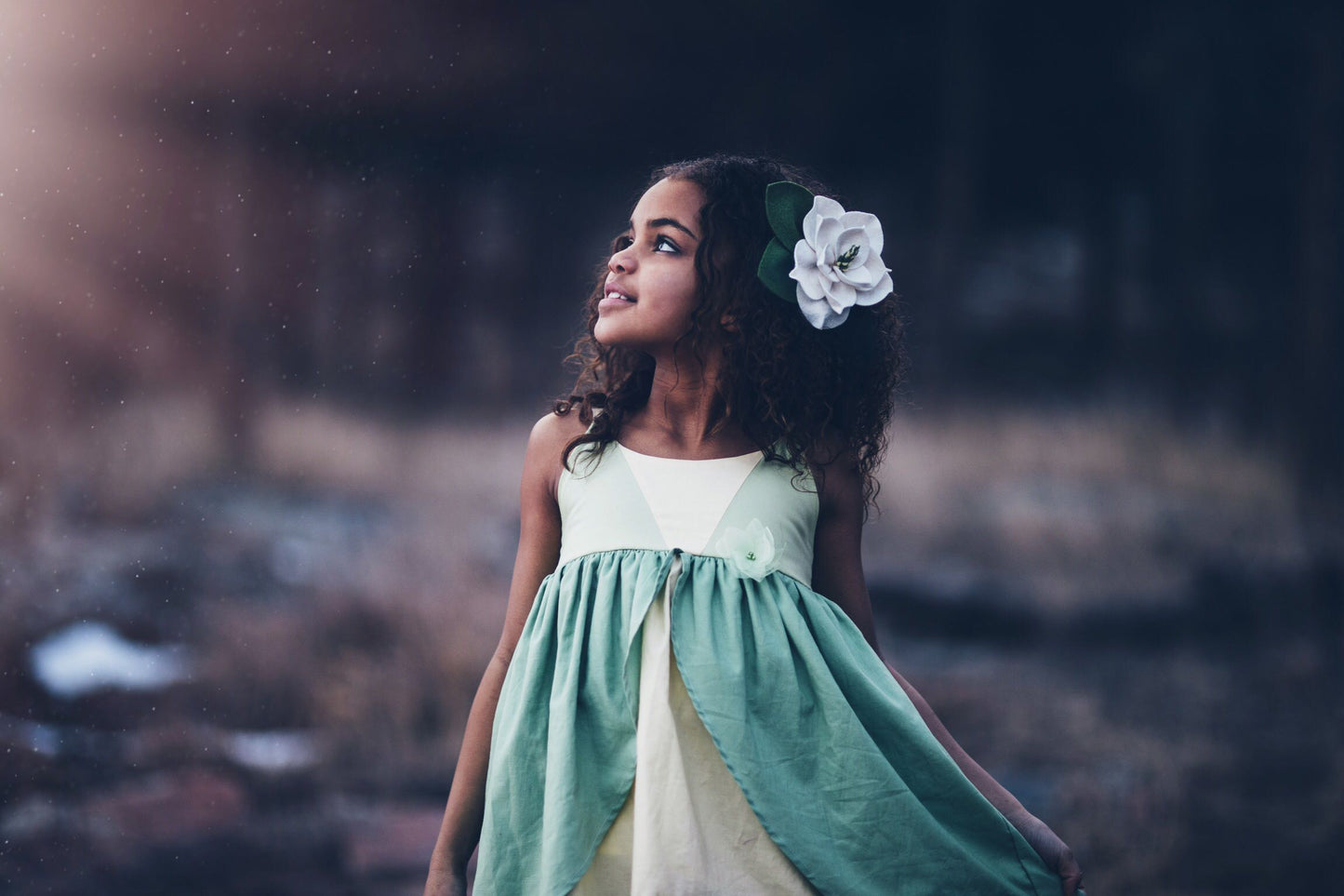 A child wearing the Tiana dress looking into the sun