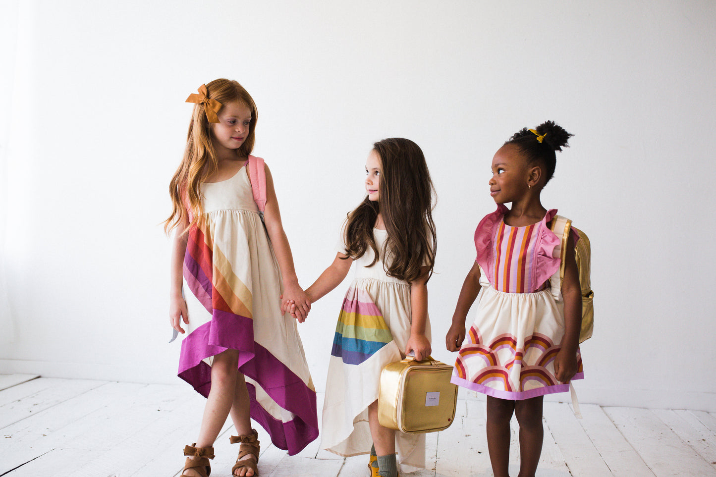 Three friends going back to school wearing the Fall Rainbow Dresses