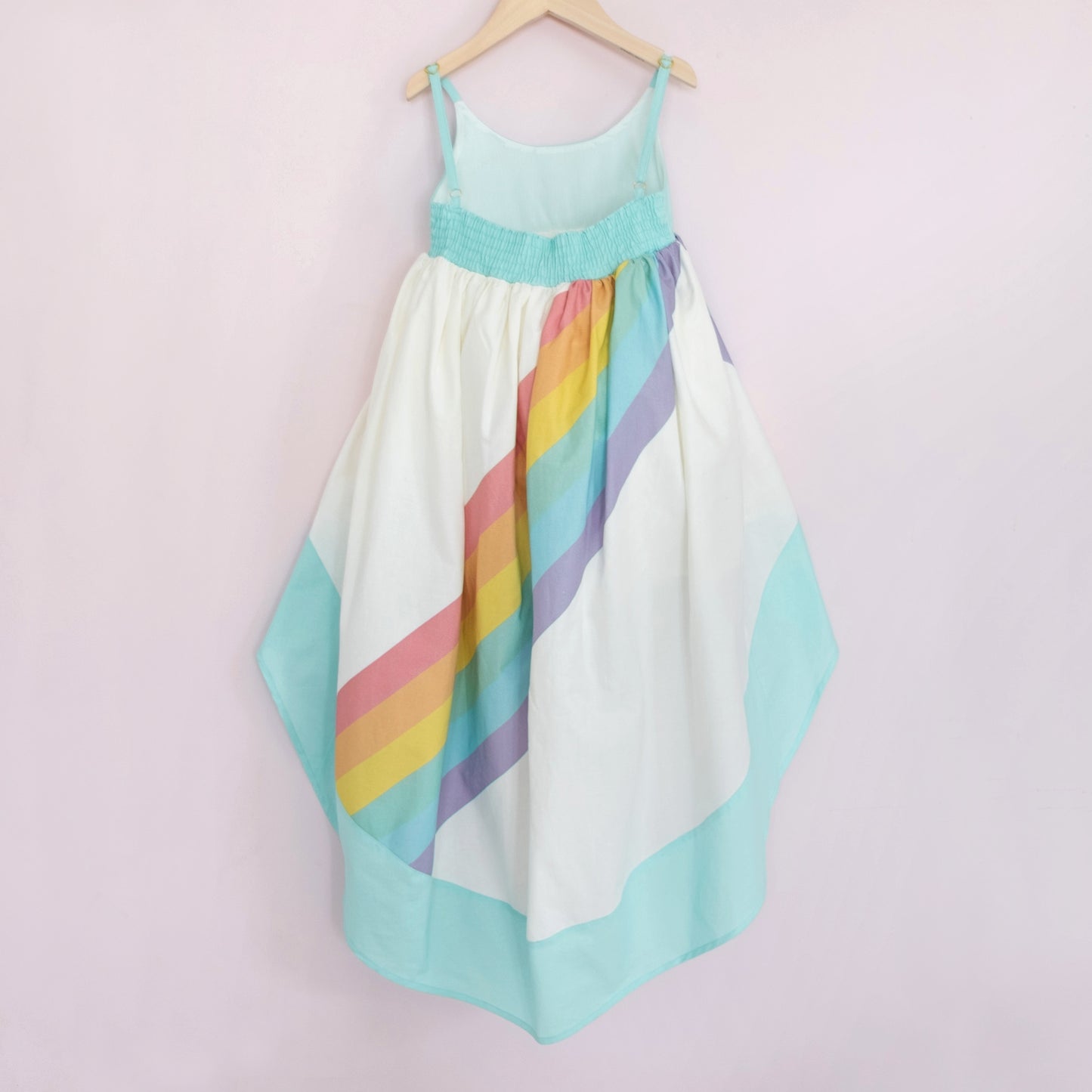 White and aqua high low dress with a bright rainbow across the back