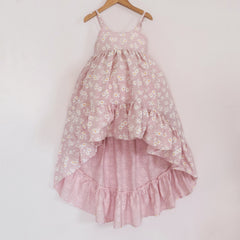 Front of a Pleiades Designs pink high low dress with a ruffle hem and a daisy pattern