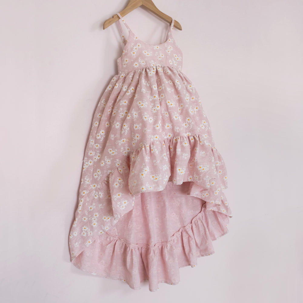 
                  
                    Front of a Pleiades Designs pink high low dress with a ruffle hem and a daisy pattern
                  
                