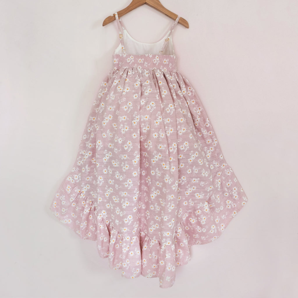 Back of a Pleiades Designs pink high low dress with a ruffle hem and a daisy pattern