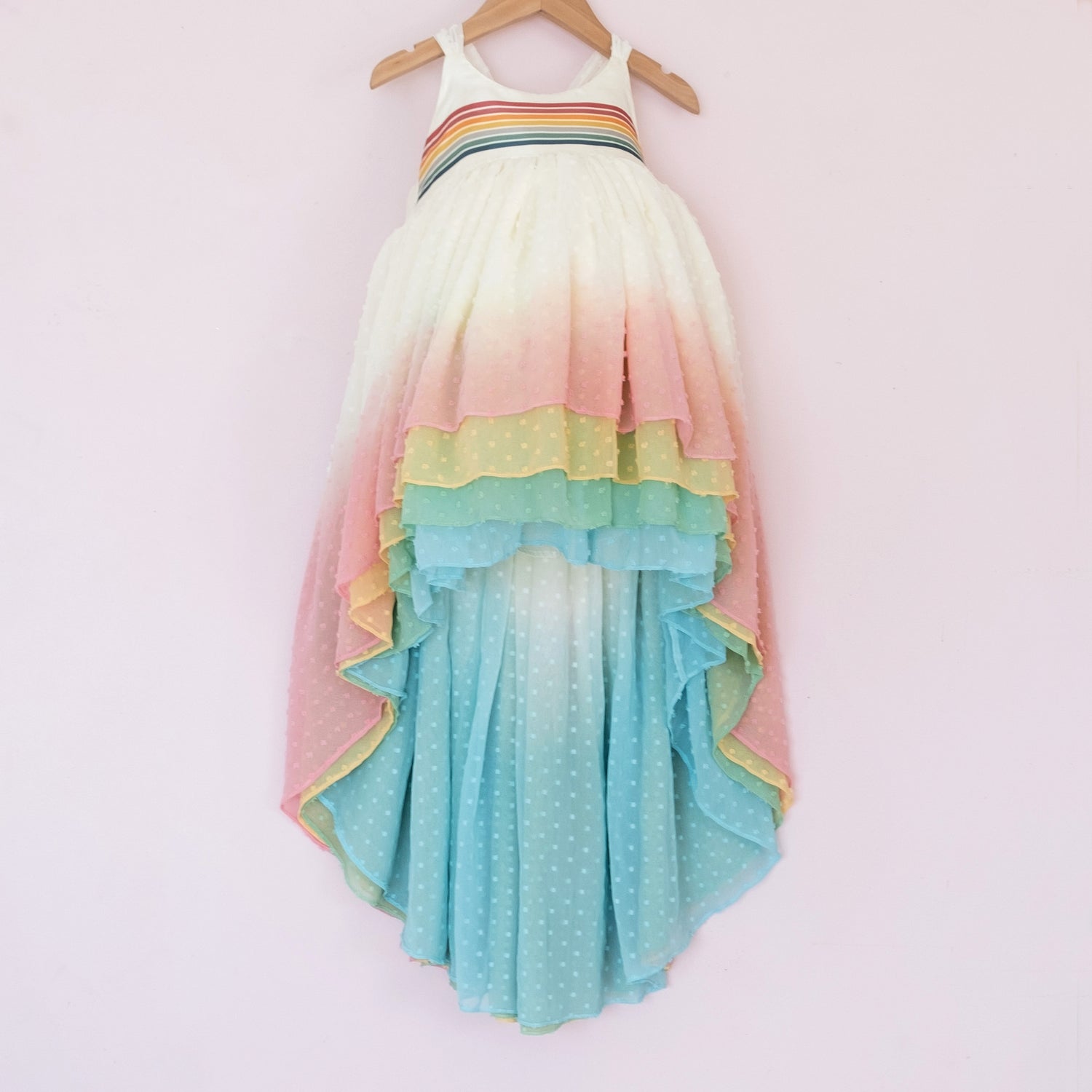 Front of a Pleiades Designs clip dot high low dress with a rainbow ombre skirt and a rainbow stripe bodice