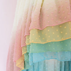 Clos up of a Pleiades Designs hem with cascading layers and dyed rainbow colors