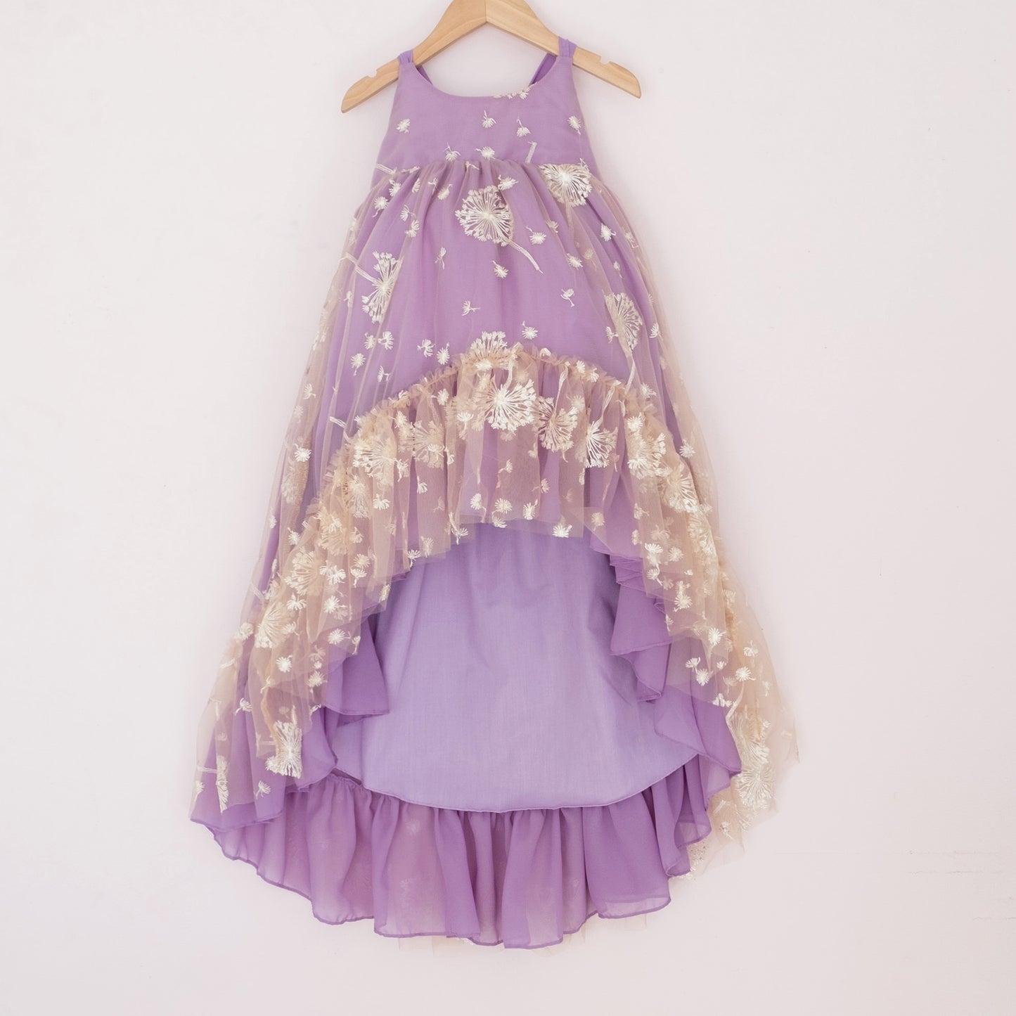 Front of a Pleiades Designs purple high low dress with white embroidered dandelions and a ruffle hem