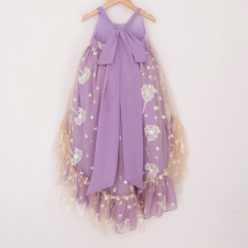 
                  
                    Back of a Pleiades Designs purple high low dress with white embroidered dandelions, a ruffle hem, and a bow back
                  
                