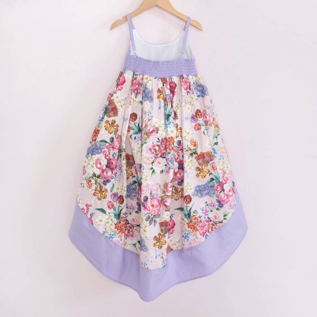 Back of a Pleiades Designs high low dress with a spring floral design and a matching purple bodice & hem