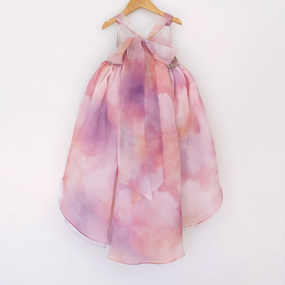 Back of a Pleiades Designs high low dress with a pink and purple cloud design and a bow back