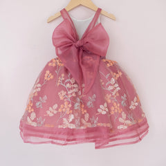 Back of a Pleiades Design short organza dress with an embroidered sequin floral and an organza bow back