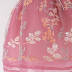 Close up of a Pleiades Designs embroidered sequin floral design over layers of mauve organza